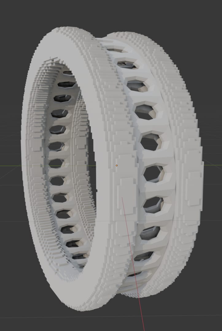 A grey Blender render of a ring built from a finer voxel structure than the coarse version — smaller blocks and a denser pattern of rounded holes, giving a more even lattice-like band.